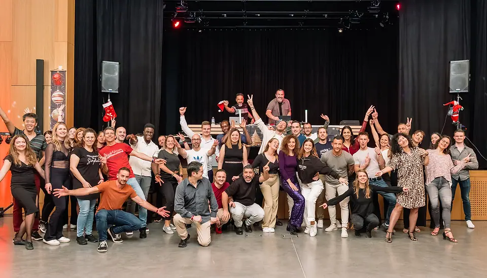 Photo de groupe, décembre 2024 : une soixantaine de personnes devant la scène, le DJ derrière les platines.