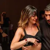 Une soirée Villa Vida : une danseuse sourit, son partenaire guide, lumière violette au fond.