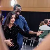 Pendant un stage, une danseuse et son partenaire, mains jointes.
